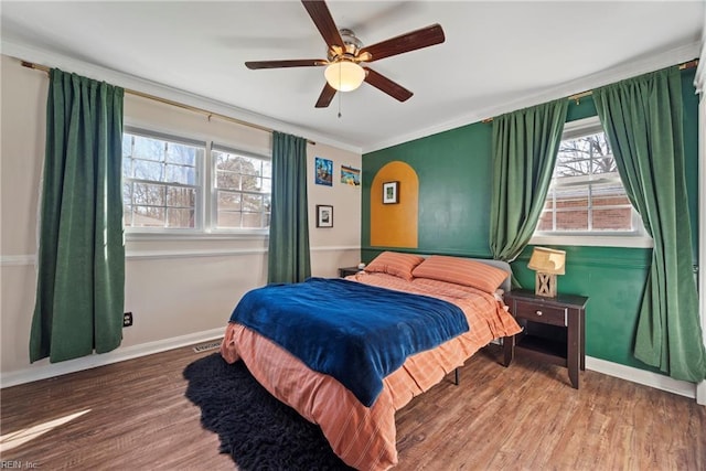 bedroom with wood finished floors, visible vents, and baseboards