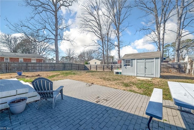 view of patio with a shed, a fenced backyard, and an outbuilding