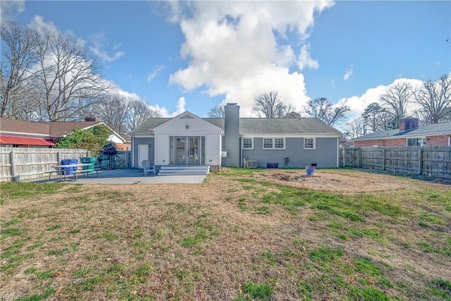 back of house featuring a patio area, a fenced backyard, a yard, and french doors