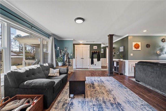 living room with ornate columns, ornamental molding, wood finished floors, and wainscoting