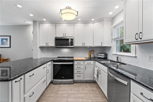 kitchen featuring recessed lighting, a peninsula, white cabinets, appliances with stainless steel finishes, and backsplash