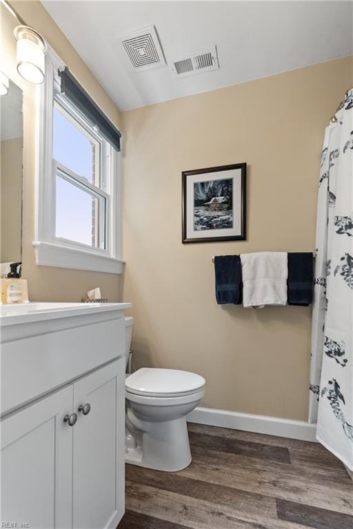 full bath with toilet, wood finished floors, vanity, and visible vents