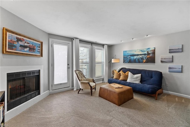 carpeted living room featuring a fireplace and baseboards