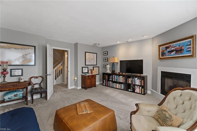 living area with baseboards, stairway, a fireplace, and light colored carpet