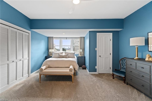 carpeted bedroom featuring a closet and baseboards