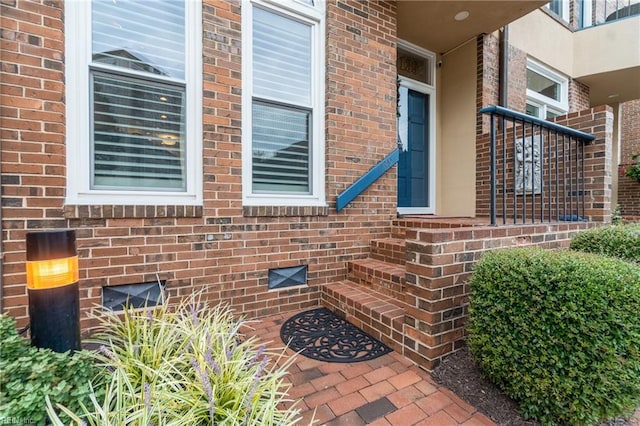 view of exterior entry featuring crawl space and brick siding