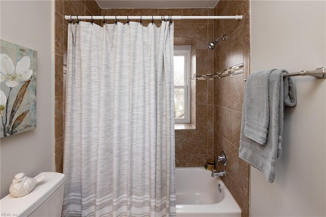 bathroom featuring shower / tub combo and toilet