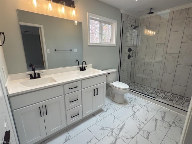 bathroom with marble finish floor, tiled shower, and a sink