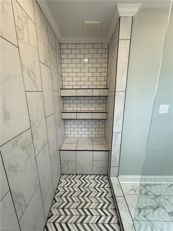 bathroom featuring marble finish floor and crown molding