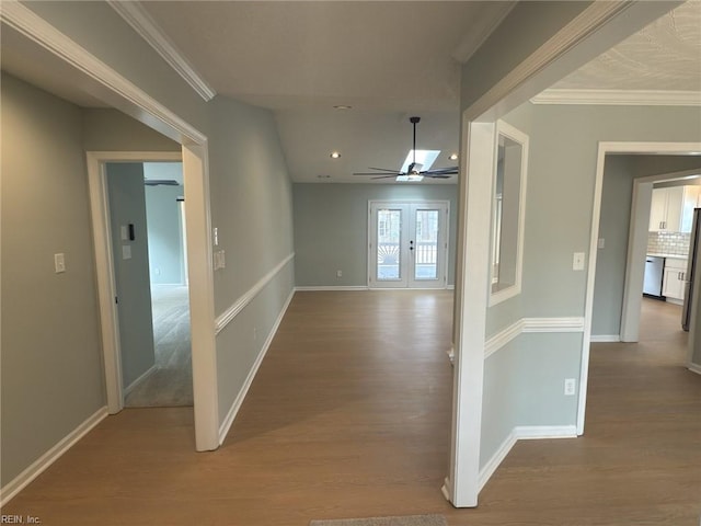 hall featuring baseboards, ornamental molding, wood finished floors, and recessed lighting