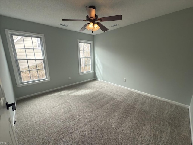 carpeted spare room with a ceiling fan, baseboards, visible vents, and a textured ceiling