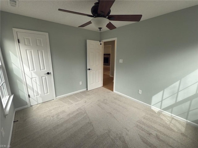 unfurnished bedroom featuring baseboards, visible vents, a textured ceiling, and carpet flooring