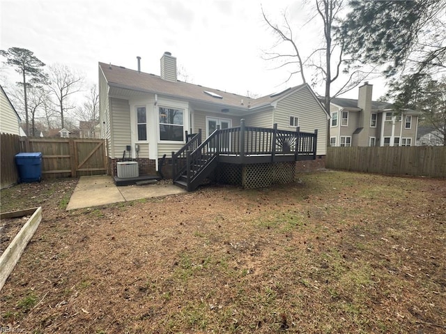 back of house featuring central air condition unit, a fenced backyard, a chimney, and a deck