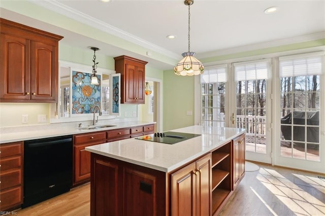 kitchen with a sink, light wood-style floors, black appliances, decorative light fixtures, and crown molding