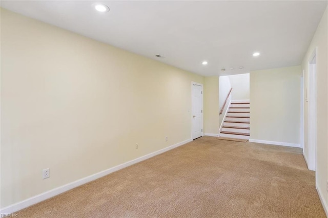 empty room featuring light carpet, visible vents, baseboards, stairs, and recessed lighting