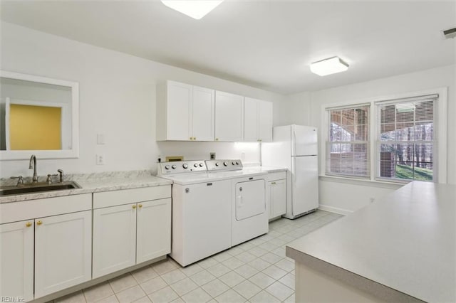 washroom featuring washer and clothes dryer, visible vents, cabinet space, light tile patterned flooring, and a sink