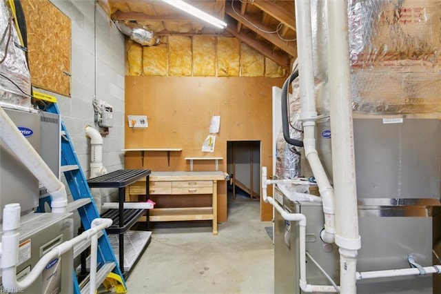 unfinished basement featuring concrete block wall and a workshop area