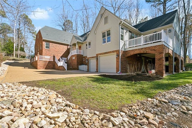 exterior space with brick siding, driveway, an attached garage, and a lawn