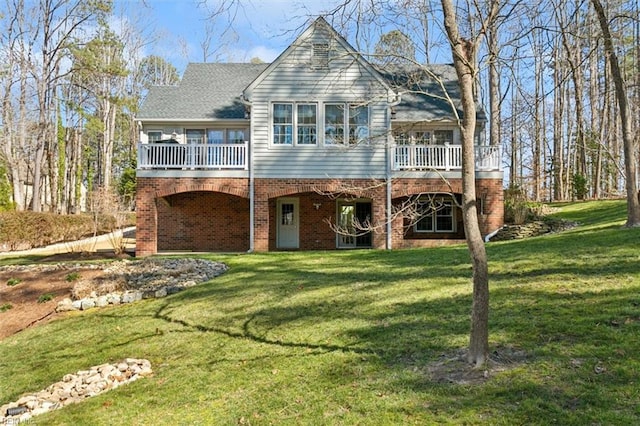 view of front of house with brick siding, a front lawn, and a wooden deck