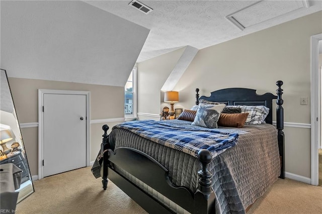 carpeted bedroom featuring a textured ceiling, visible vents, baseboards, vaulted ceiling, and attic access