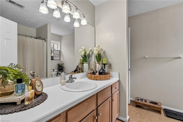 full bath with tile patterned flooring, visible vents, vanity, and baseboards