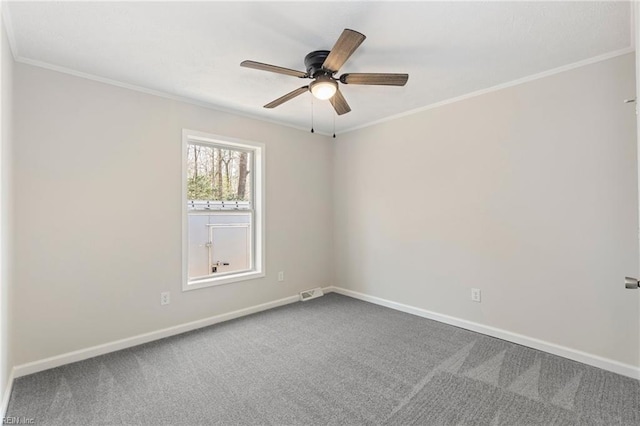 carpeted empty room with ornamental molding, a ceiling fan, and baseboards