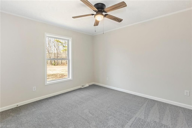 carpeted empty room featuring baseboards, visible vents, and crown molding