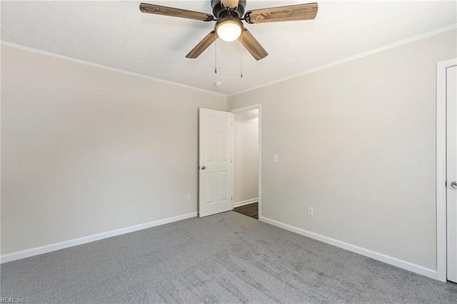 unfurnished room with carpet floors, a ceiling fan, baseboards, and crown molding