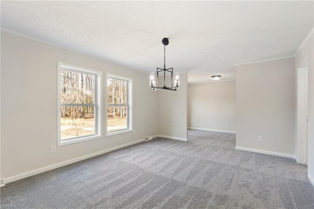 carpeted spare room featuring a notable chandelier, a textured ceiling, baseboards, and crown molding