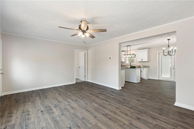 unfurnished living room featuring baseboards, dark wood-style floors, ornamental molding, a textured ceiling, and ceiling fan with notable chandelier