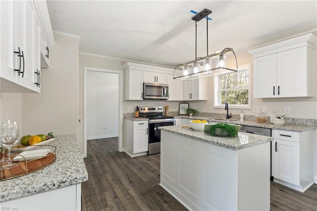 kitchen featuring stainless steel appliances, a sink, white cabinets, dark wood-style floors, and crown molding