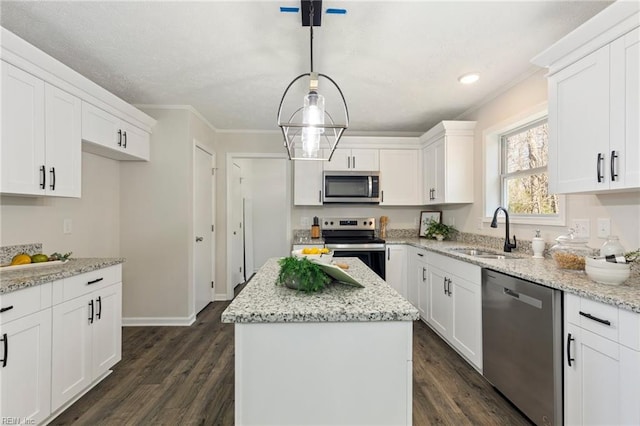 kitchen with a kitchen island, appliances with stainless steel finishes, white cabinets, and a sink