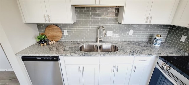 kitchen featuring white cabinets, decorative backsplash, stainless steel appliances, and a sink