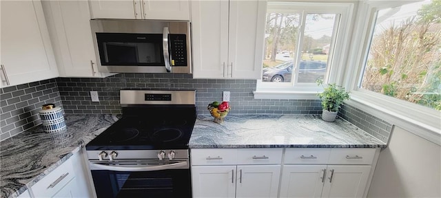 kitchen featuring light stone counters, appliances with stainless steel finishes, backsplash, and white cabinetry