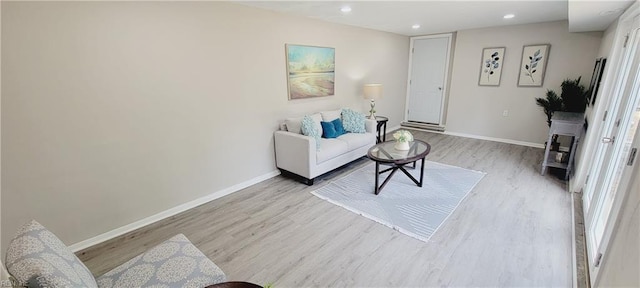 living room with baseboards, recessed lighting, and light wood-style floors