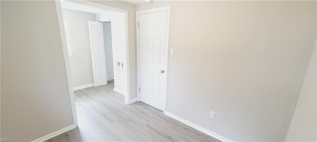 hallway with light wood finished floors and baseboards