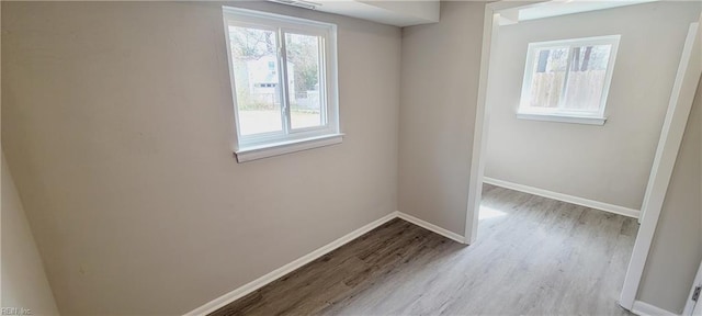 unfurnished room with baseboards and wood finished floors