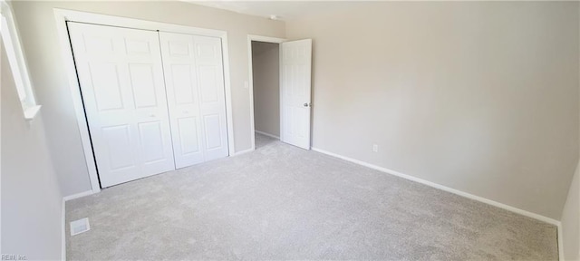 unfurnished bedroom with carpet floors, baseboards, and a closet