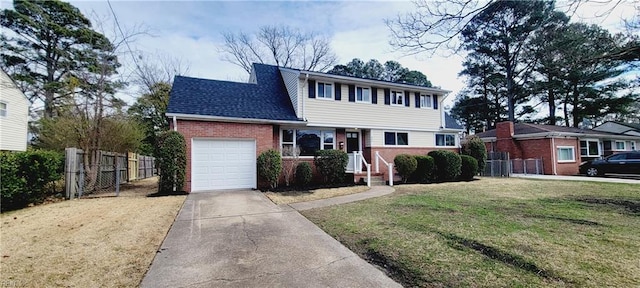 view of front facade with driveway, brick siding, an attached garage, fence, and a front yard