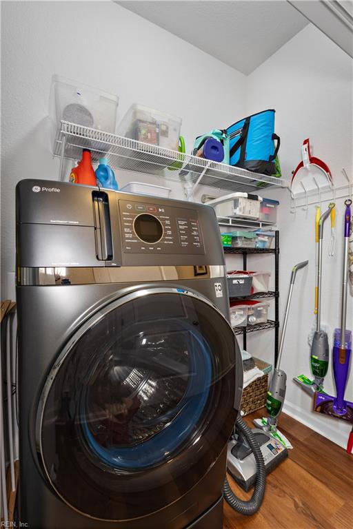 washroom featuring washer / dryer, laundry area, and wood finished floors