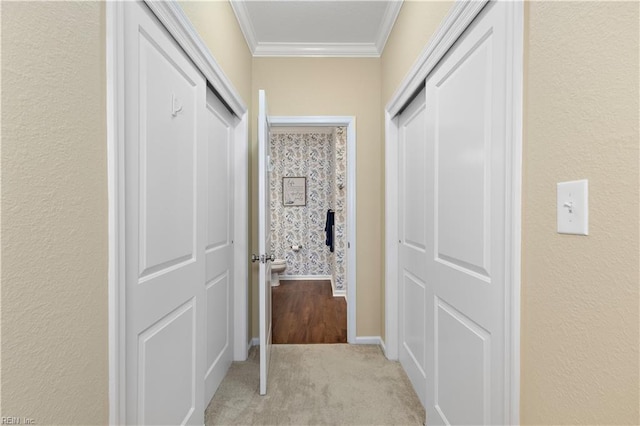 corridor with light carpet, baseboards, and crown molding