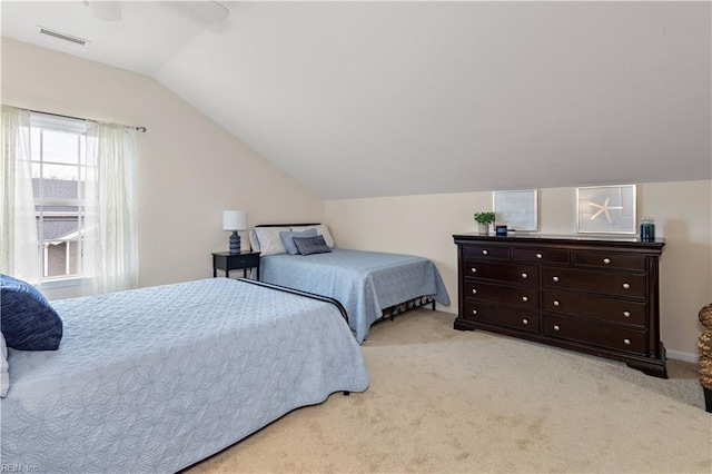 bedroom with light carpet, visible vents, and vaulted ceiling