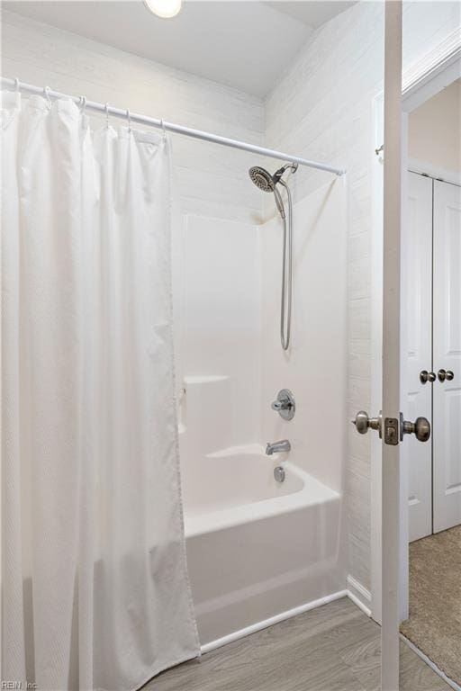 bathroom with shower / bathtub combination with curtain and wood finished floors