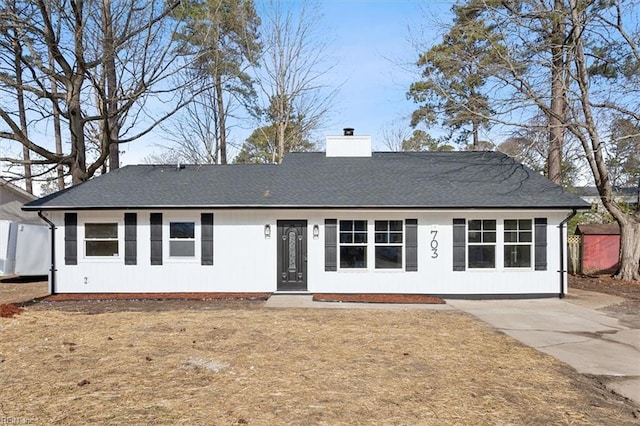 view of front of home with roof with shingles and a chimney