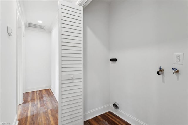 clothes washing area featuring hookup for an electric dryer, laundry area, wood finished floors, visible vents, and baseboards