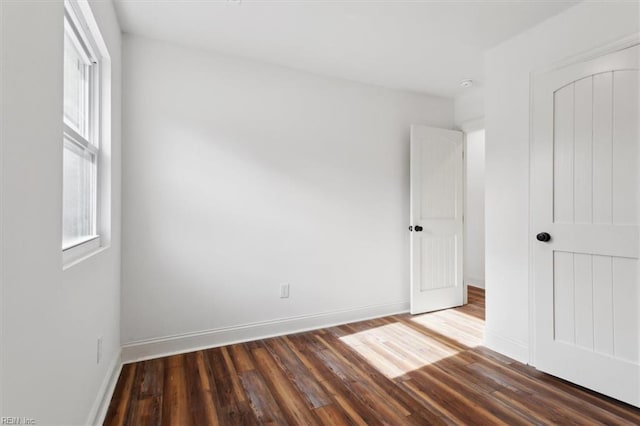 unfurnished bedroom with a closet, baseboards, and wood finished floors