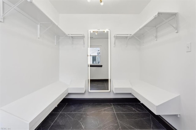 walk in closet featuring marble finish floor