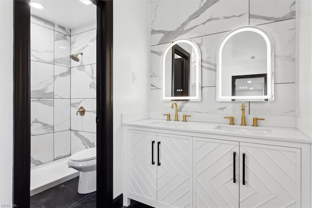 full bathroom featuring double vanity, a stall shower, toilet, and a sink