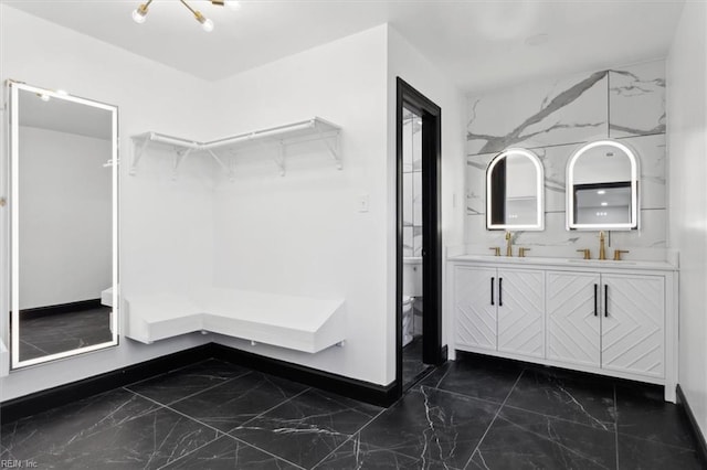 interior space with marble finish floor, a sink, and double vanity