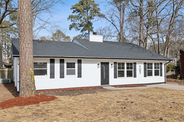 view of front of property featuring a chimney and roof with shingles